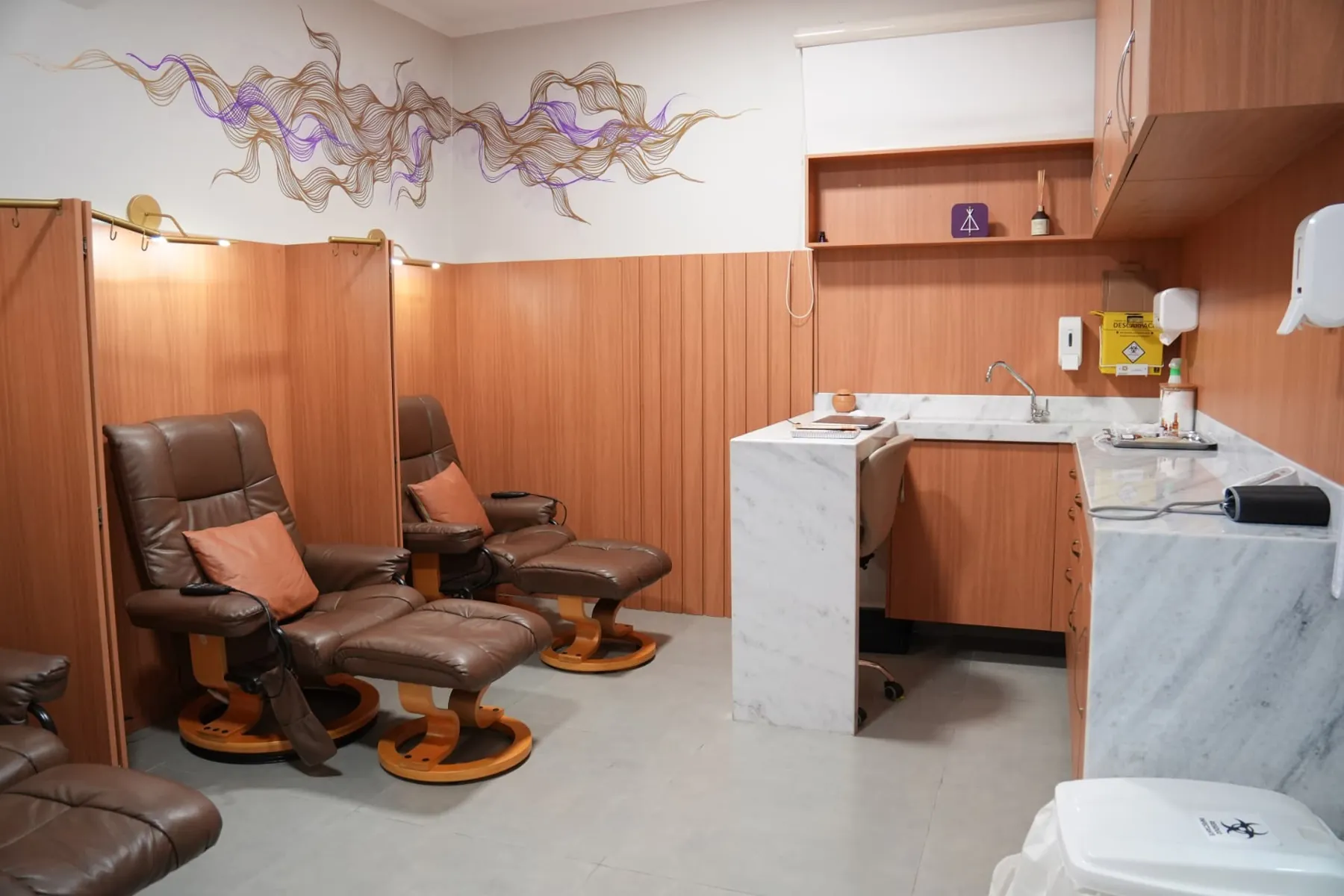 Vista ampla da Sala Turmalina com poltronas reclináveis, biombos e bancada de preparo em mármore