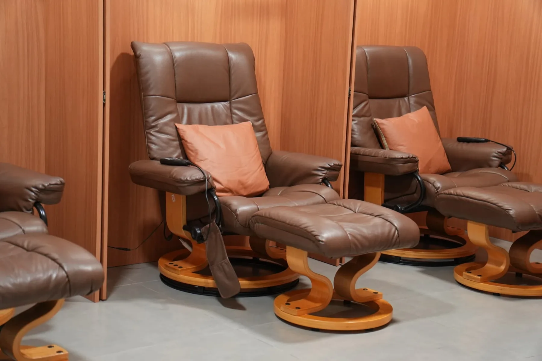 Poltronas reclináveis de couro com apoio para pernas e controle na lateral